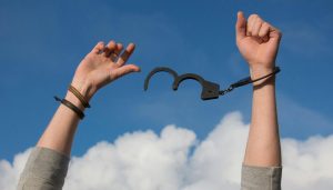 ow angle view of person freed from handcuffs representing breaking the anxiety cycle.