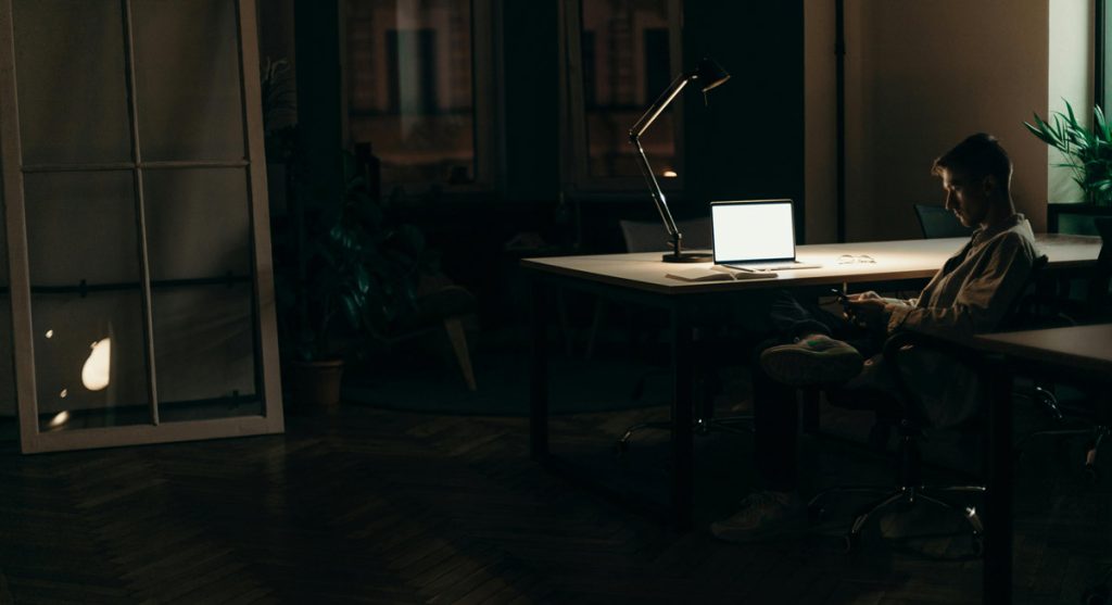 Man working on laptop at desk representing struggles with focus and compulsive behavior.