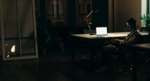 Man working on laptop at desk representing struggles with focus and compulsive behavior.