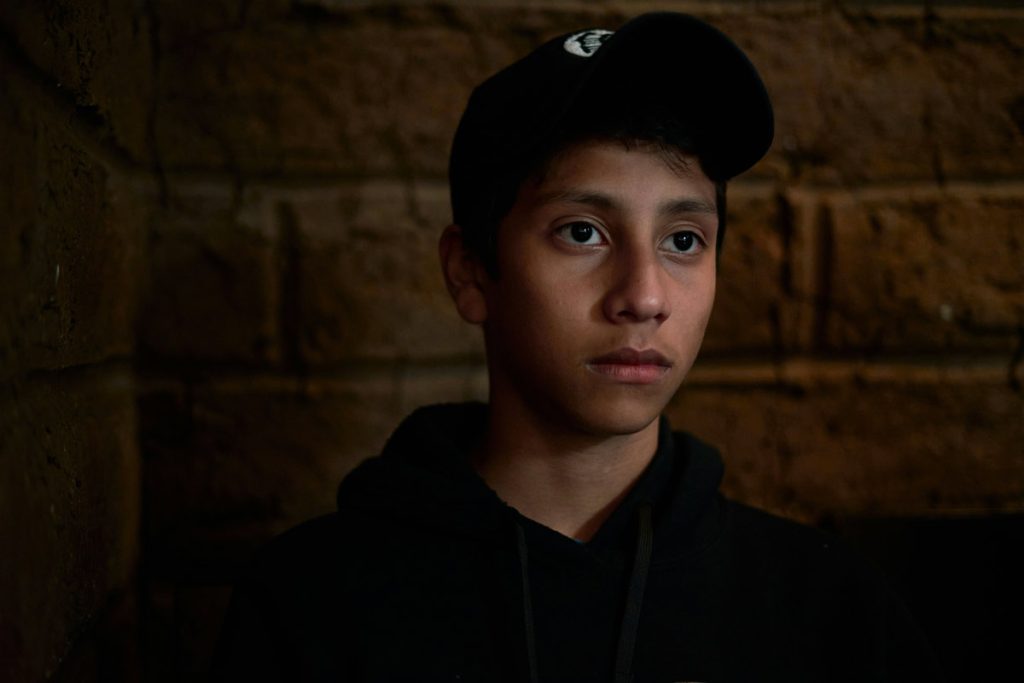 Young person sitting alone looking contemplative, representing teens facing language barriers in mental health care.
