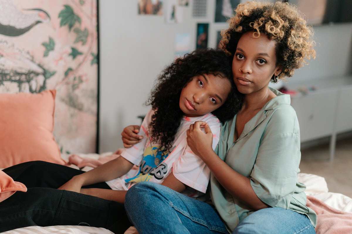 Mother and daughter in an intimate moment together, representing the generational connection and transmission of trauma patterns through families