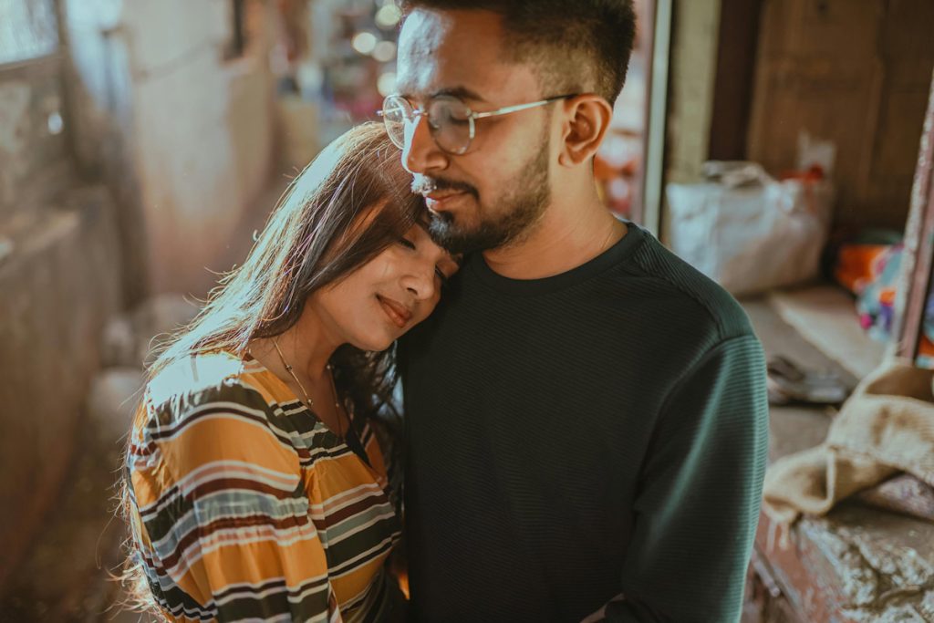 Couple embracing tenderly in home setting showing secure attachment and emotional connection after healing conflict.