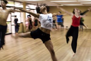 Dancers moving expressively in a studio, illustrating creative expression for mental health