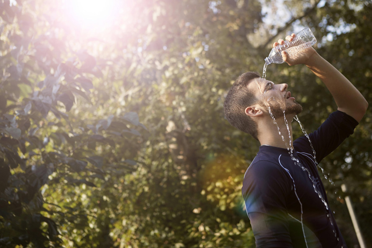 A man pouring cold water over his face outdoors, illustrating cold exposure as a vagus nerve exercise for nervous system reset.