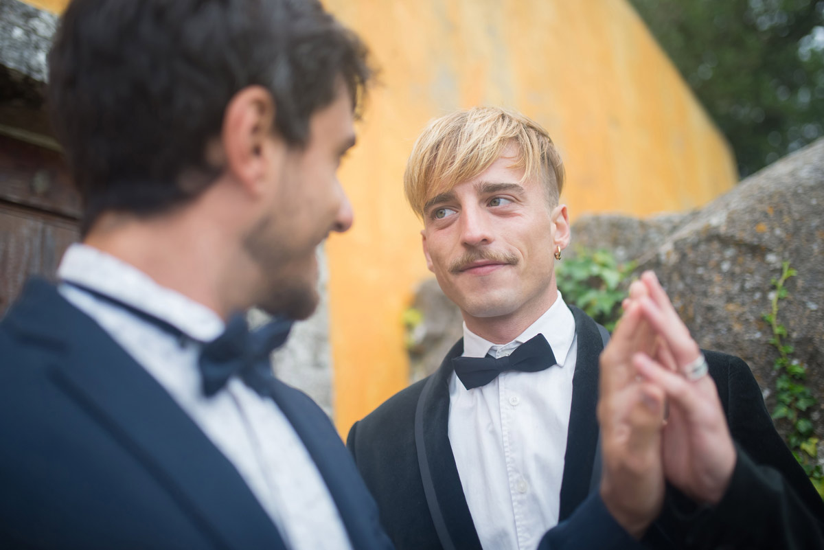 Close-up of two grooms sharing a tender moment during their wedding, reflecting love and connection despite relationship anxiety.