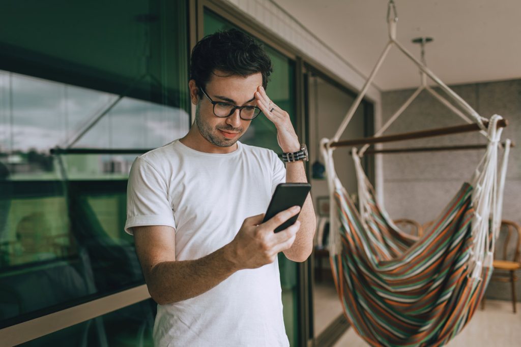 Man looking stressed while checking his phone.