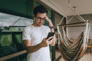 Man looking stressed while checking his phone.