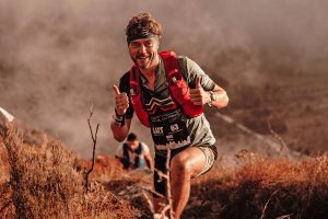 Man running on a mountain trail, representing resilience and mental health after cancer.
