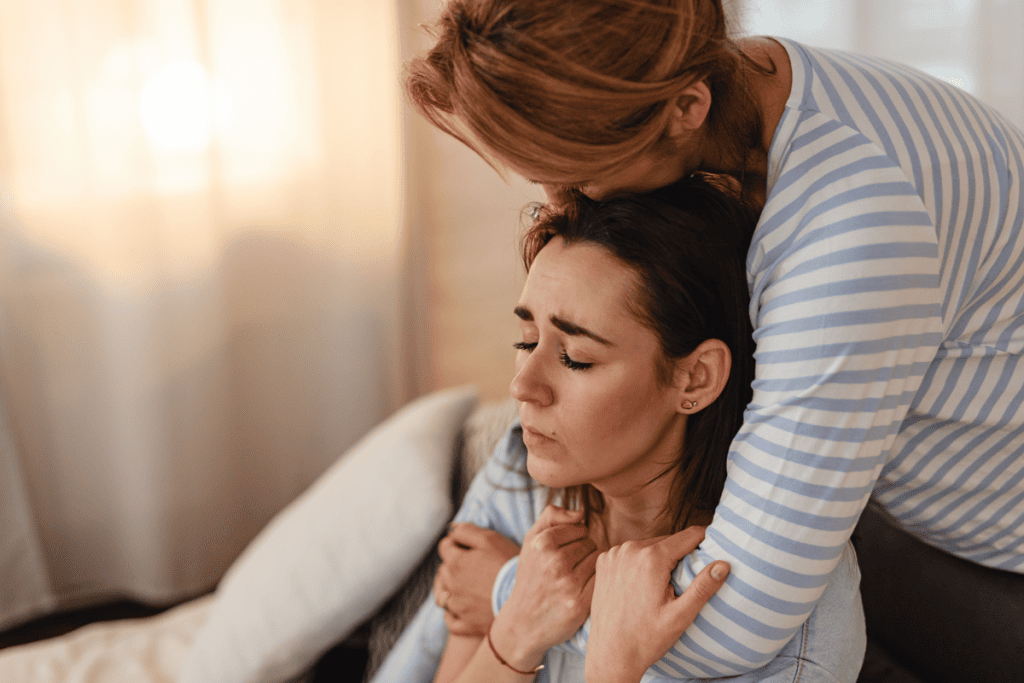 Parent embracing an adult child who is struggling, showing family support when a loved one refuses addiction treatment.